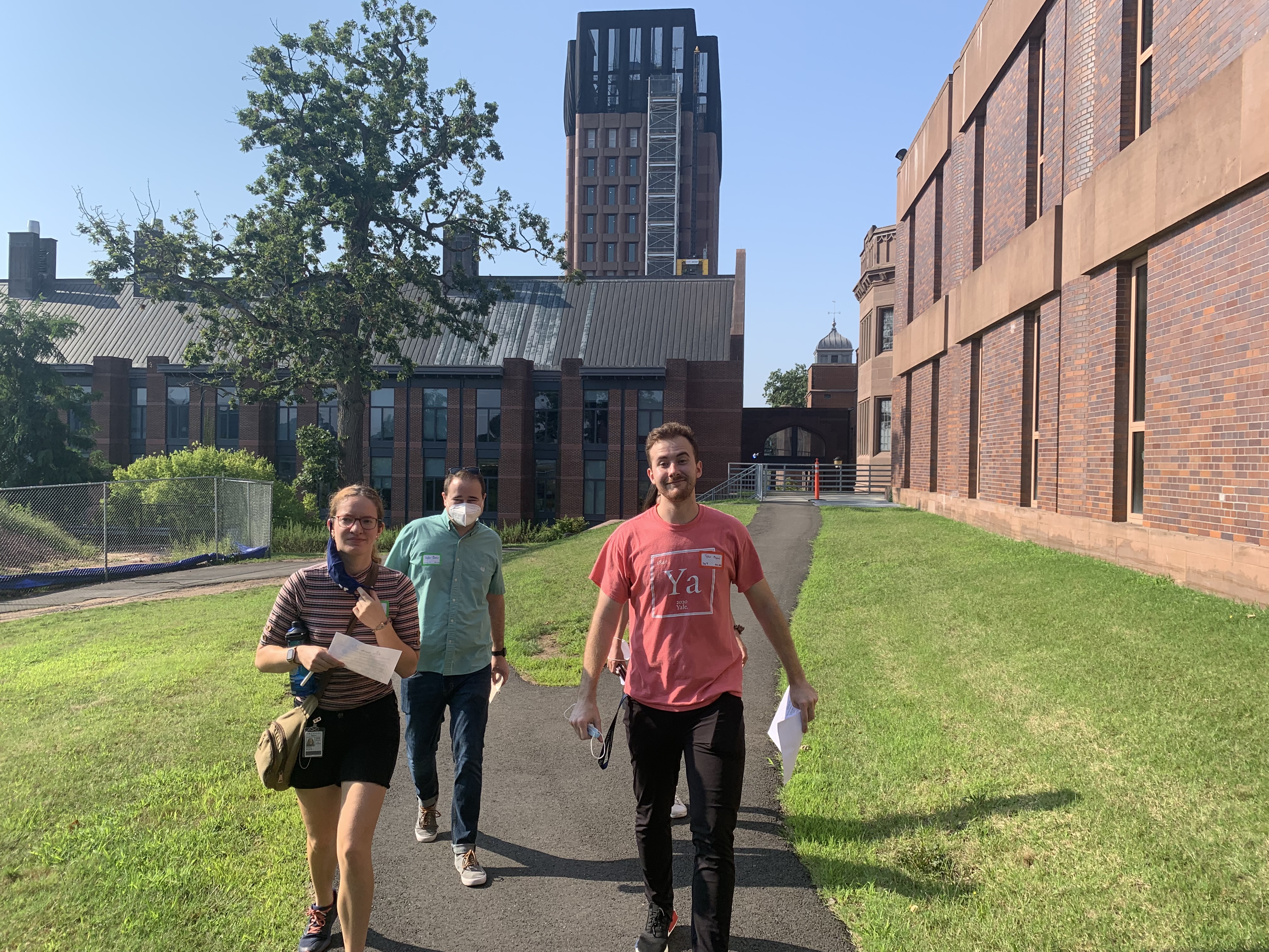 people walking outside near brick building