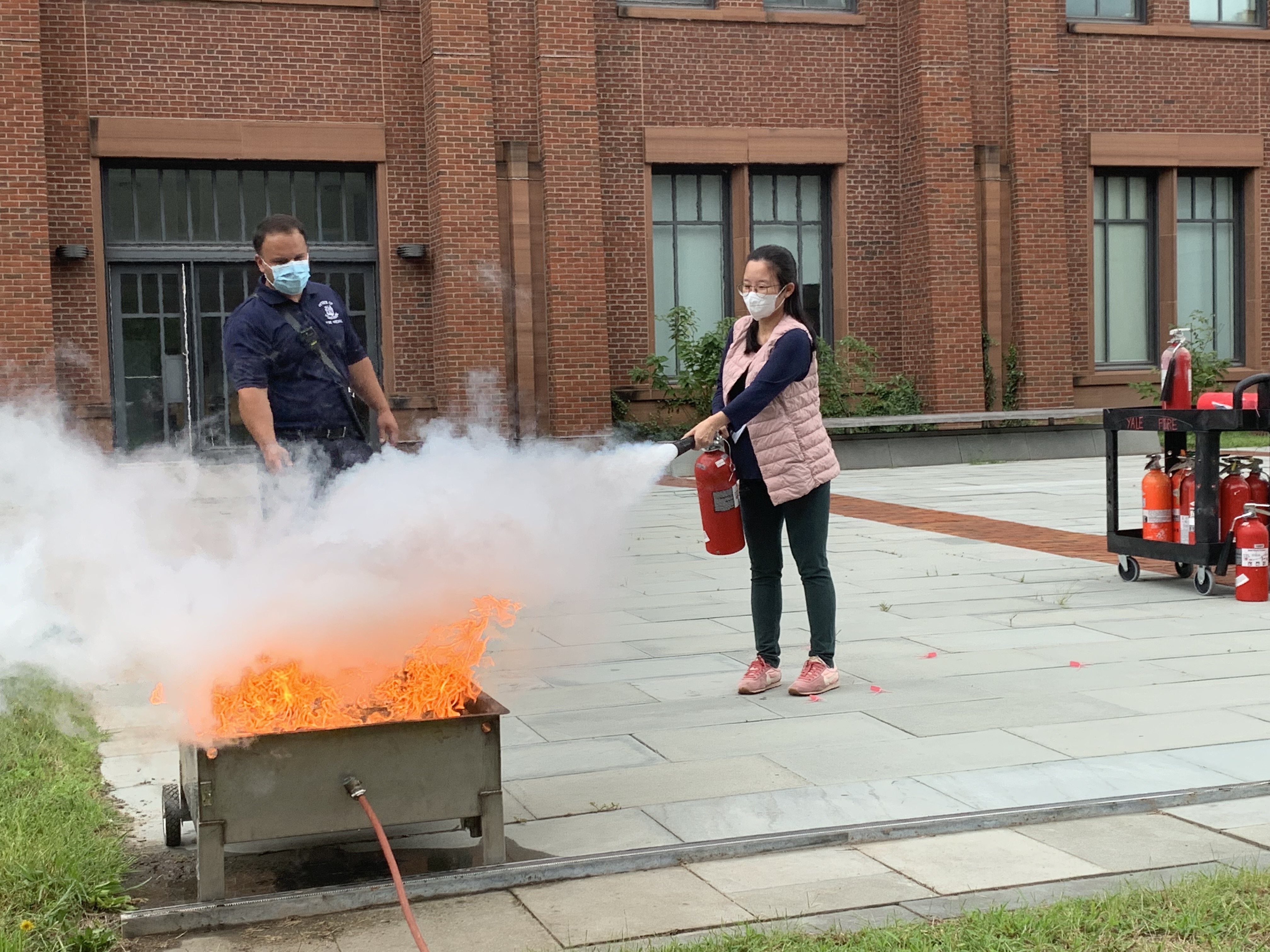 woman using fire extinguisher on fire