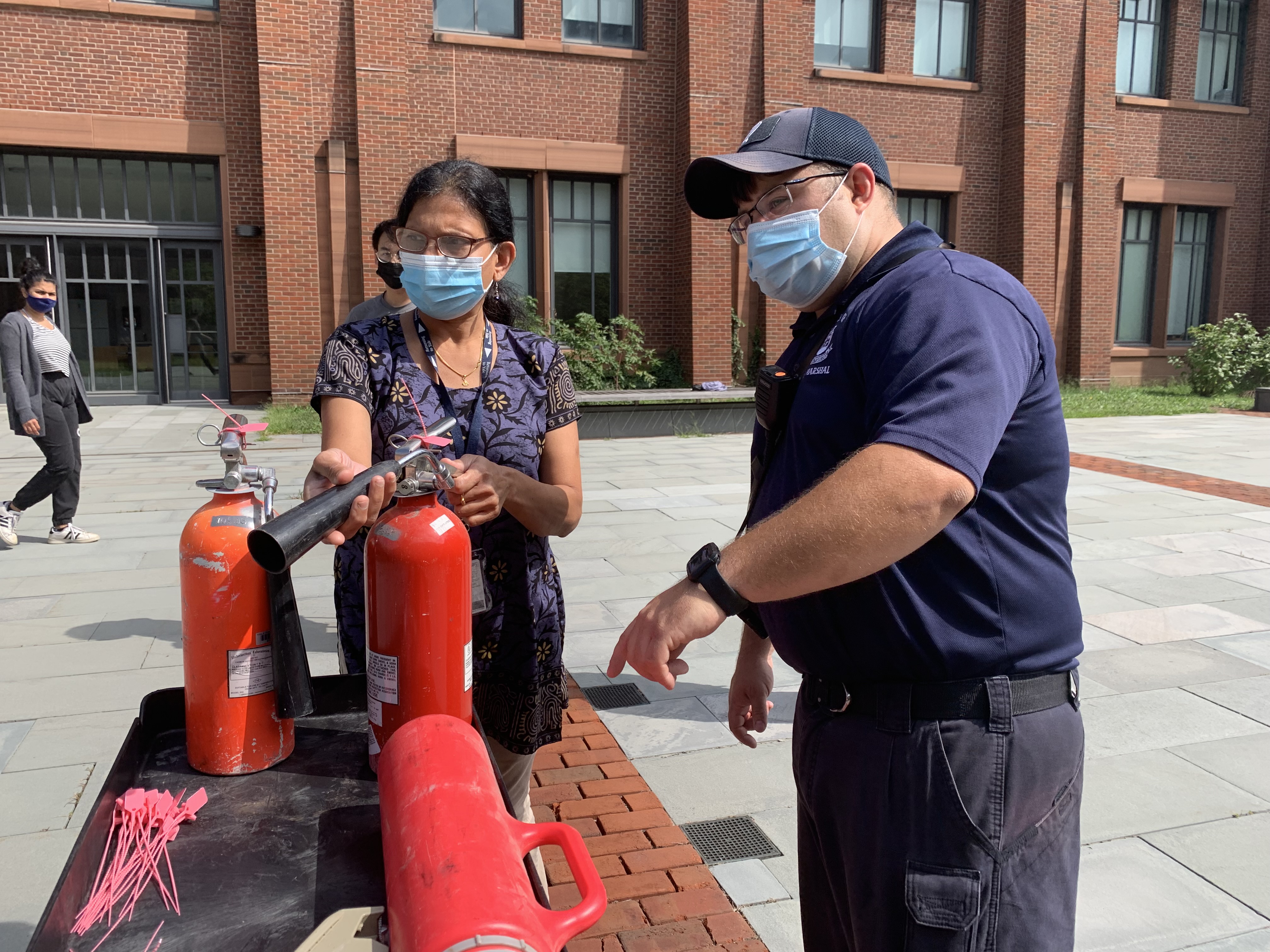 woman pointing nozzle of fire extinguisher