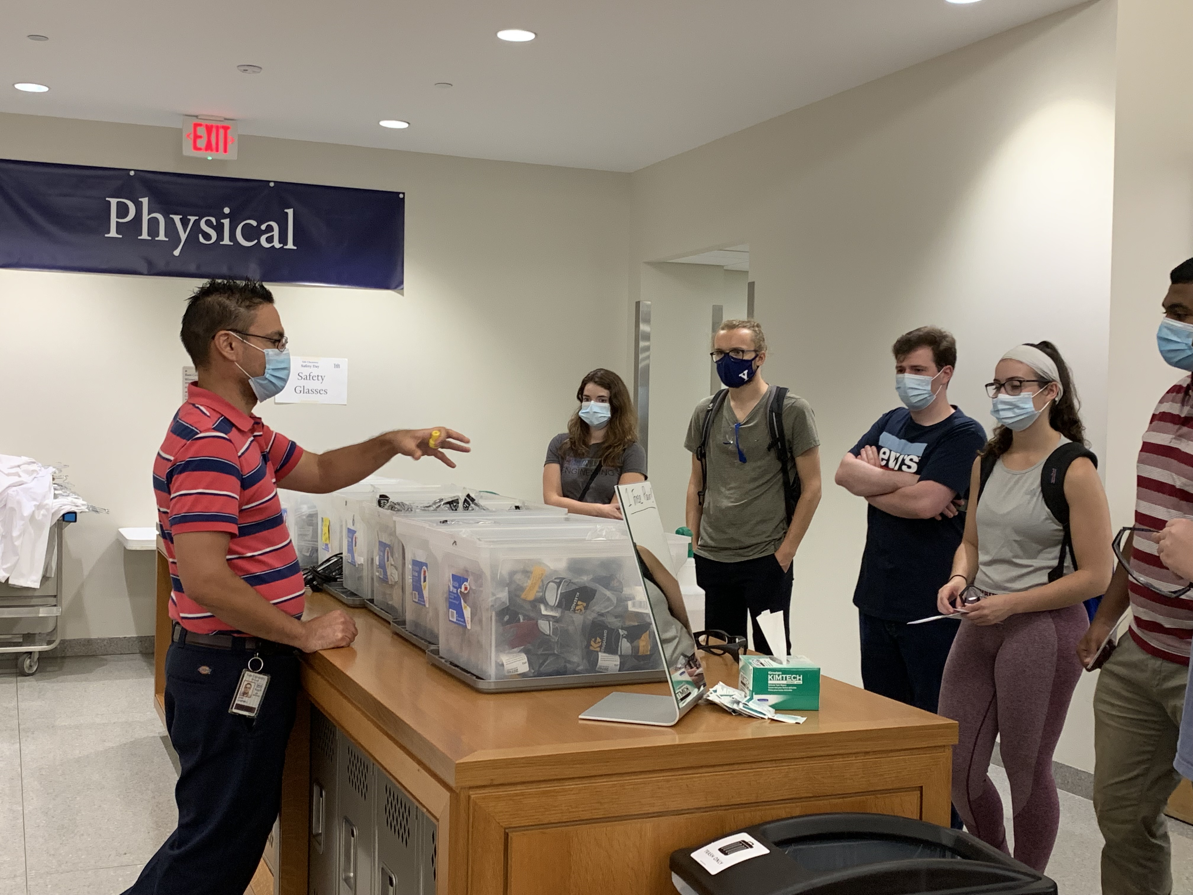 people surrounding bins of goggles