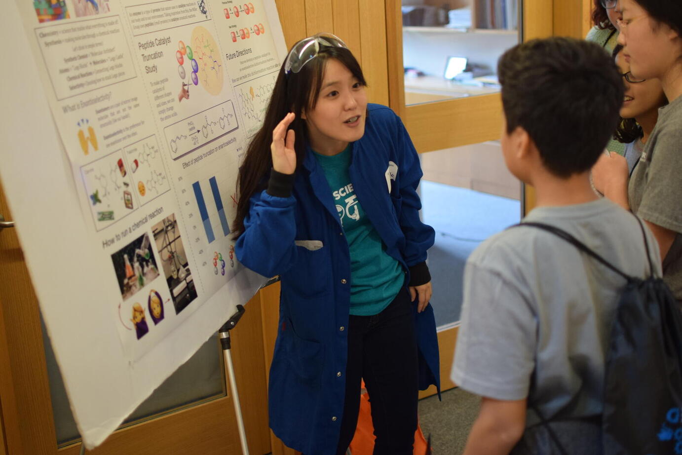 woman presenting poster to kids