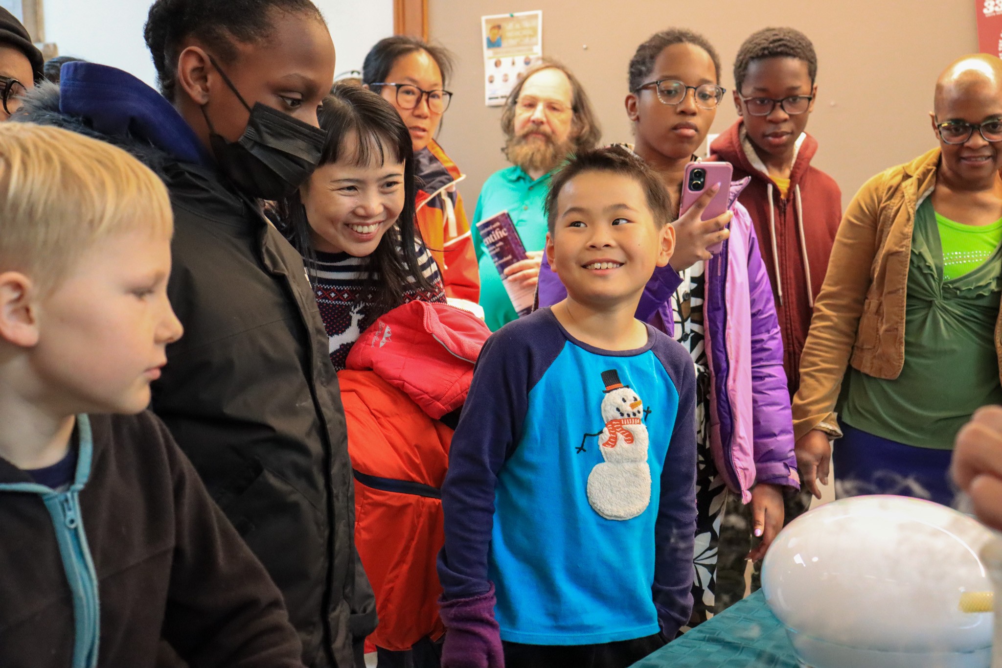 children and adults looking at bubble experiment on table