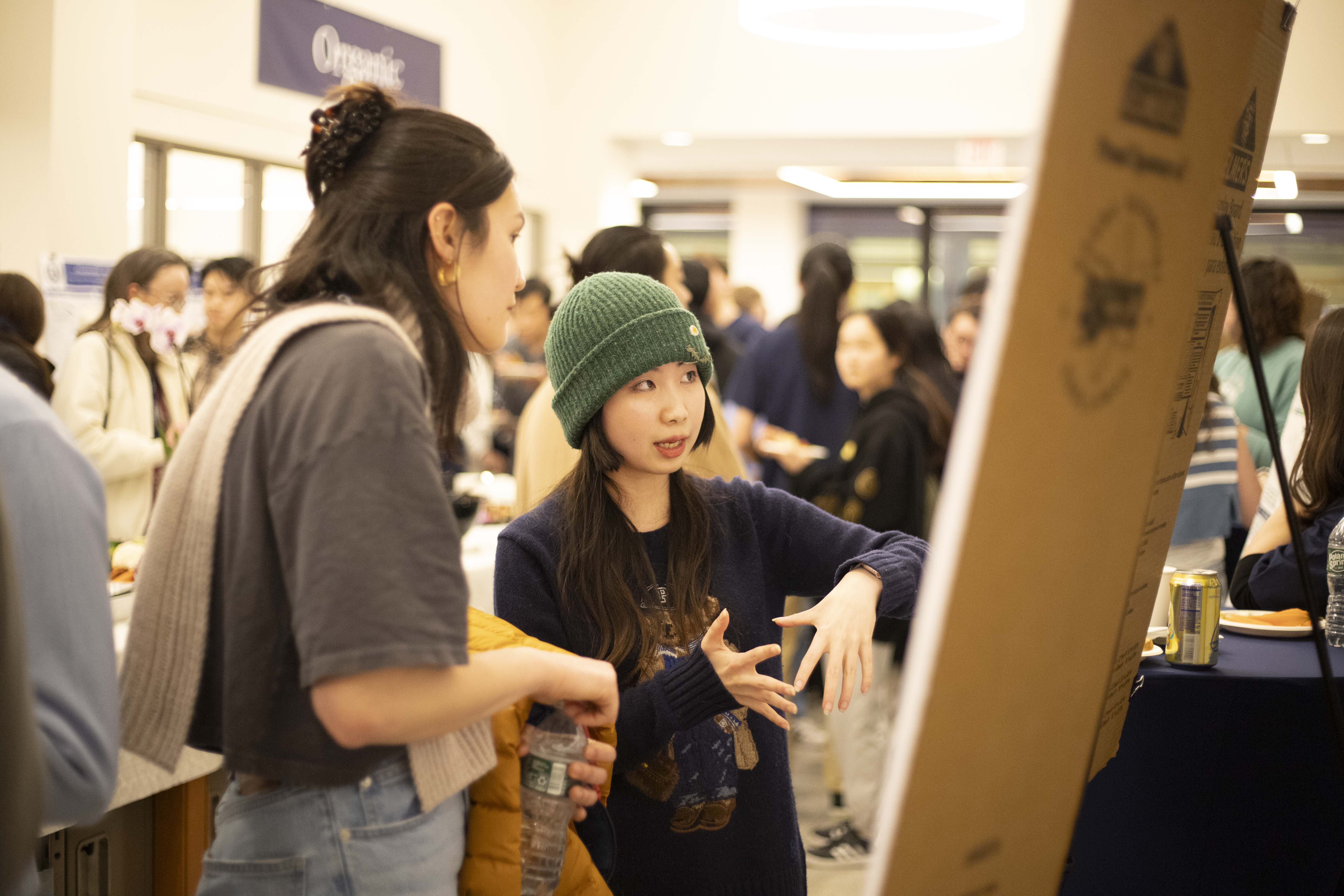student explaining research on poster