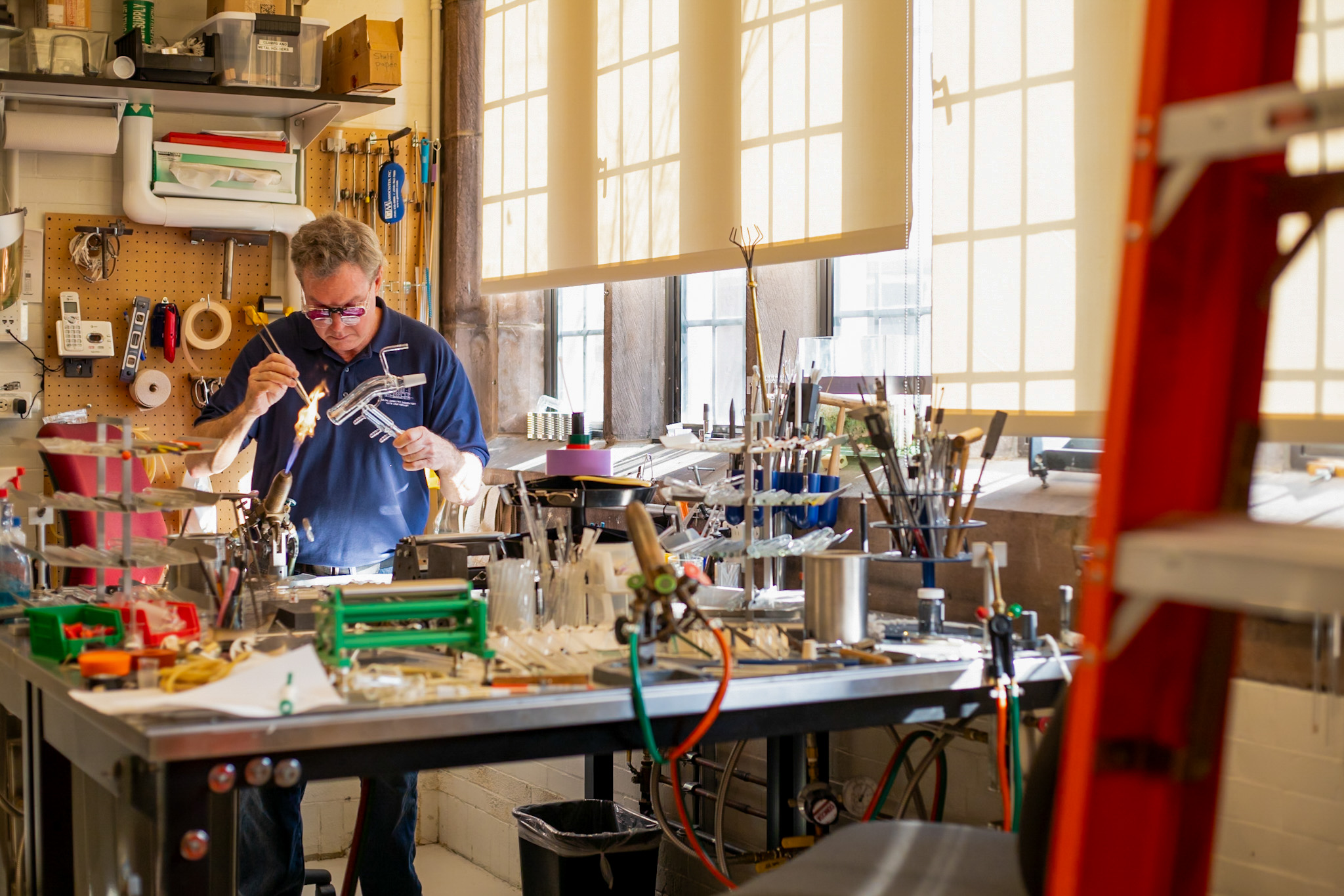 man using glassblowing instrument in shop