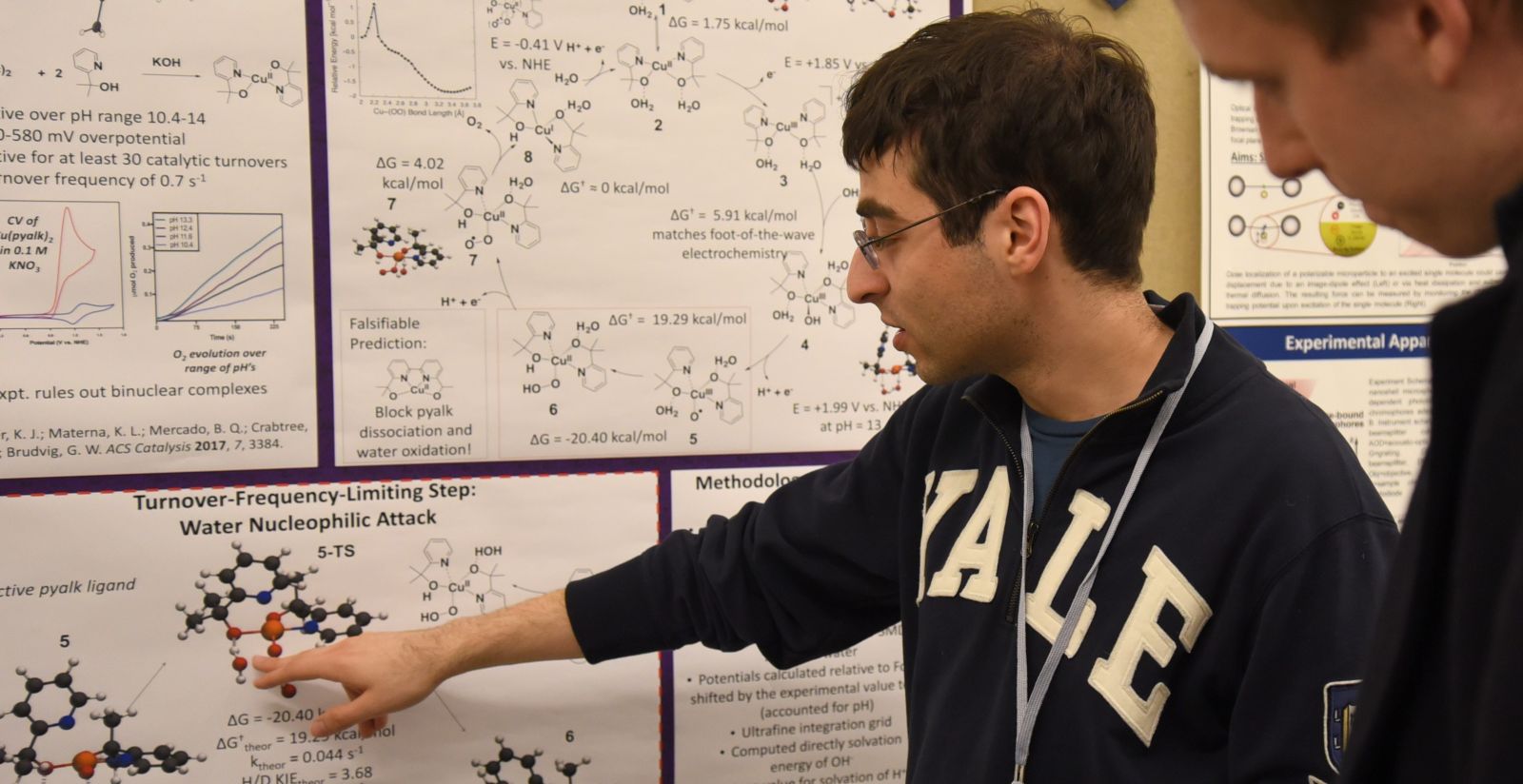 student pointing a research poster