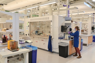 woman in large lab with fume hoods