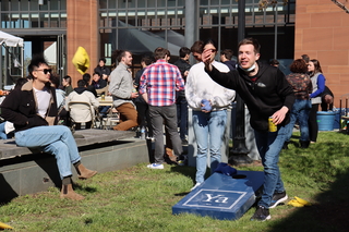 man tossing corn hole bag