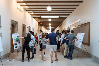 People standing near posters in long hallway