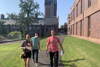 people walking outside near brick building