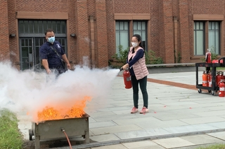 woman using fire extinguisher on fire