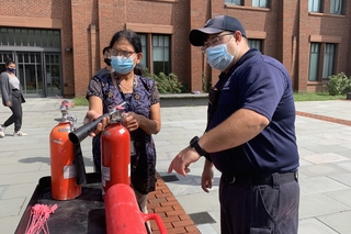 woman pointing nozzle of fire extinguisher