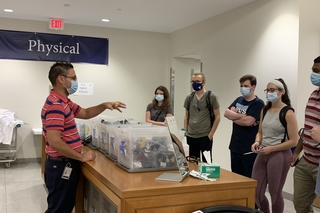 people surrounding bins of goggles