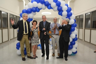 Man holding giant scissors people clapping