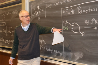 man pointing to blackboard