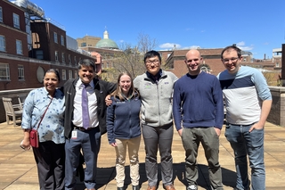 six people standing in courtyard