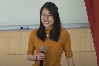 woman smiling holding mic