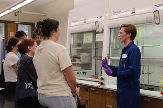 crowd watching man in lab coat speak