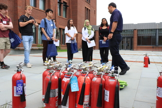 guy talking to crowd near fire extinguishers