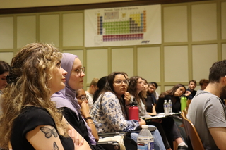 people in audience listening and watching lecturer
