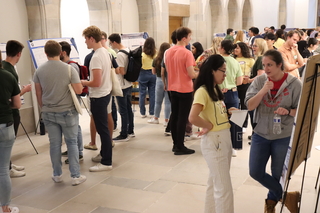 people talking by research posters 
