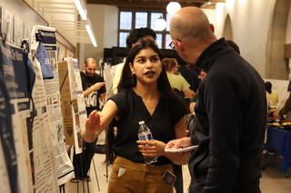 woman explaining to man by research poster