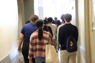 backs of people walking down hallway