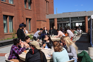 people sitting eating at tables outside courtyard