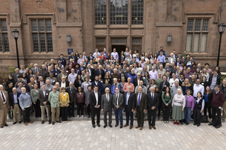 large group in front of brick building