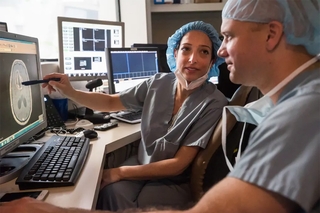 people in scrubs pointing to brain image 