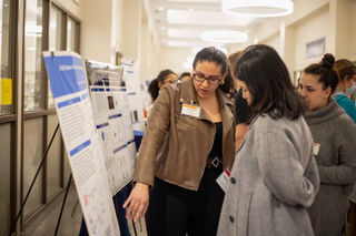 women pointing at poster