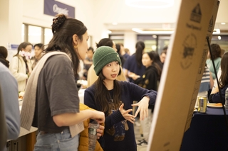 student explaining research on poster 