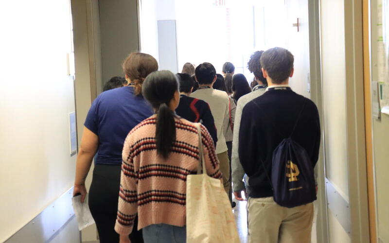 backs of people walking down hallway