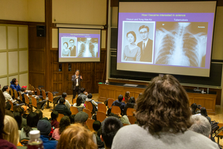 crowd in lecture hall watching slideshow