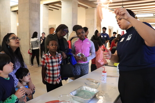 woman lighting a paper towel on fire children watch