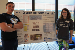 two people standing next to poster