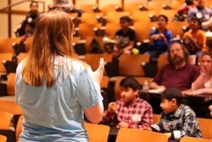 woman presenting to audience of children