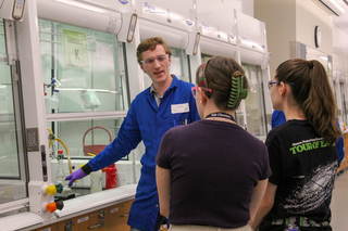 man pointing to chemical in fume hood