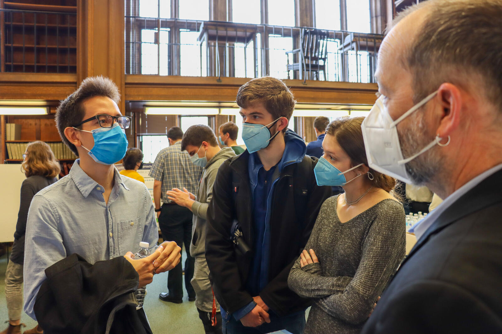 Man talking to group wearing masks