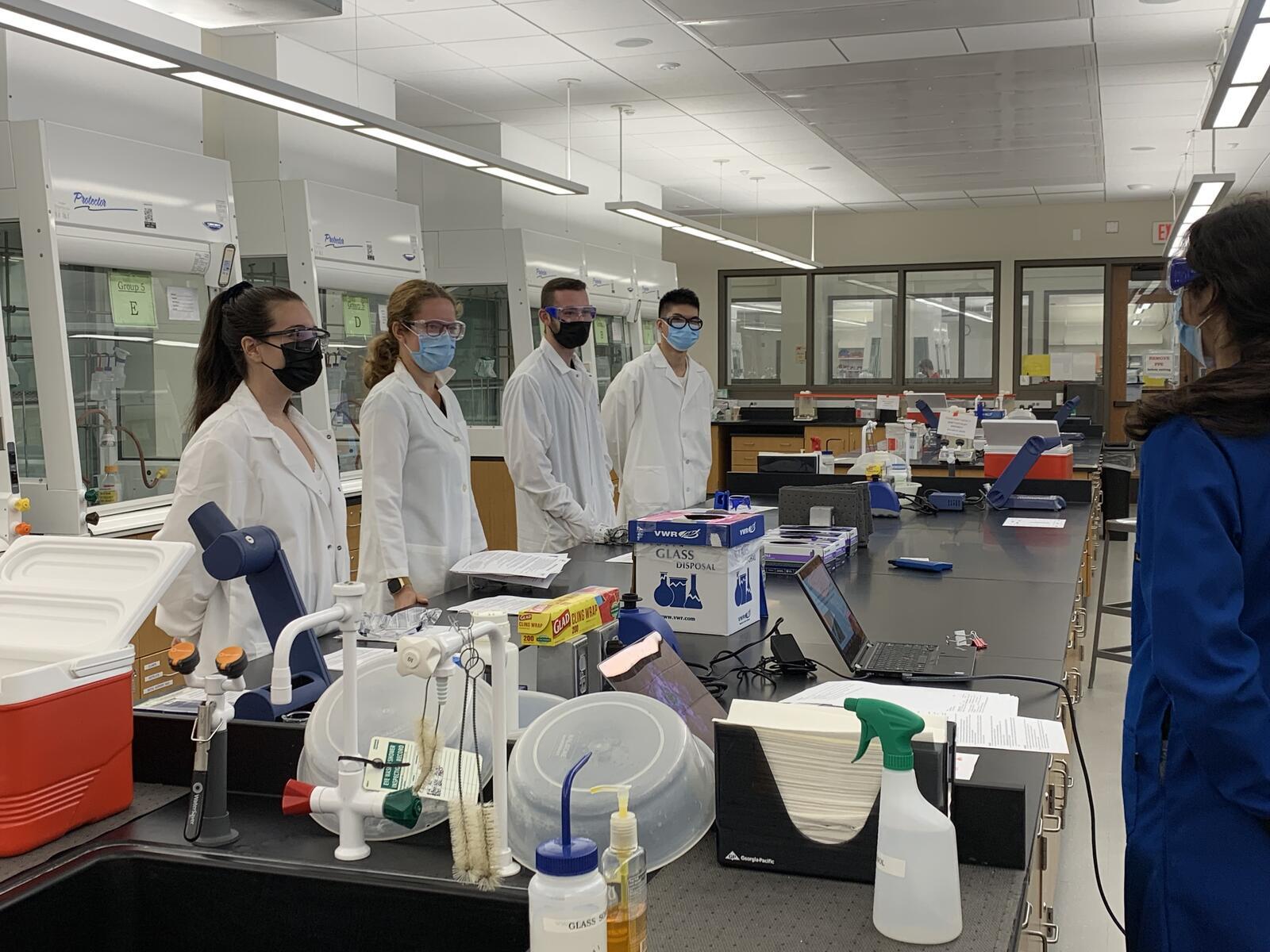 Chemistry students standing at bench