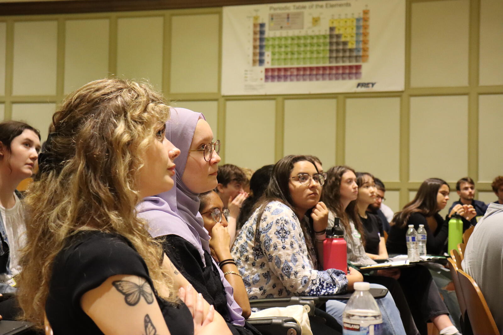 people in audience listening and watching lecturer