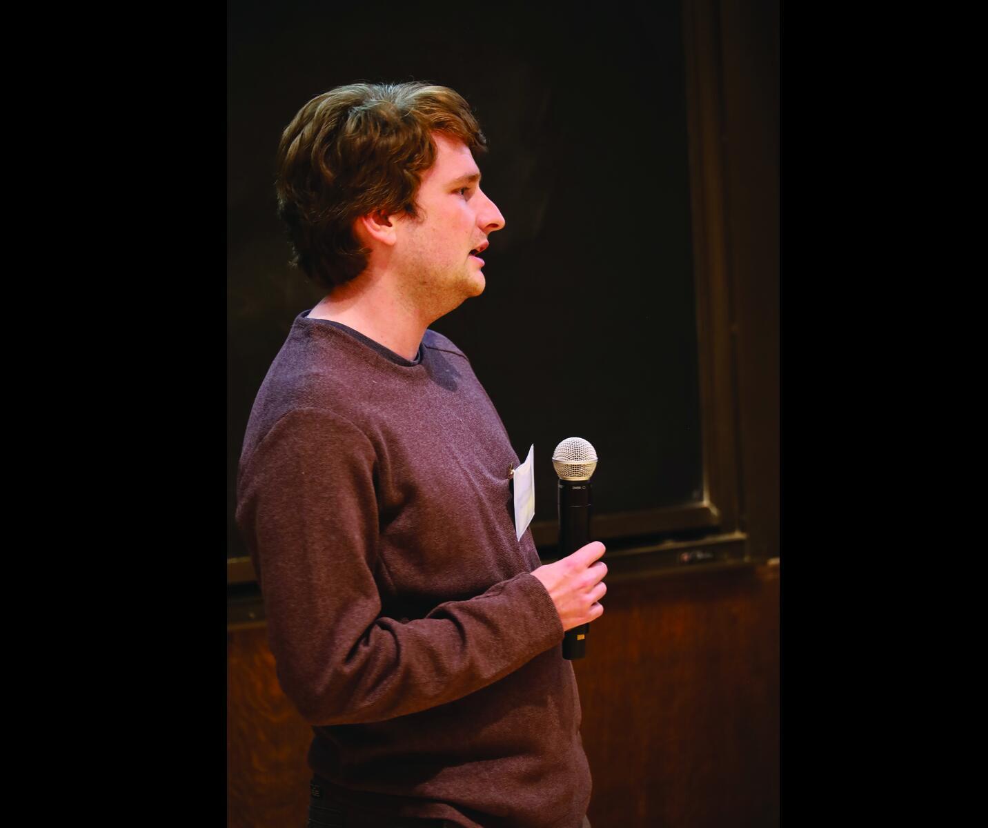 Man speaking holding microphone